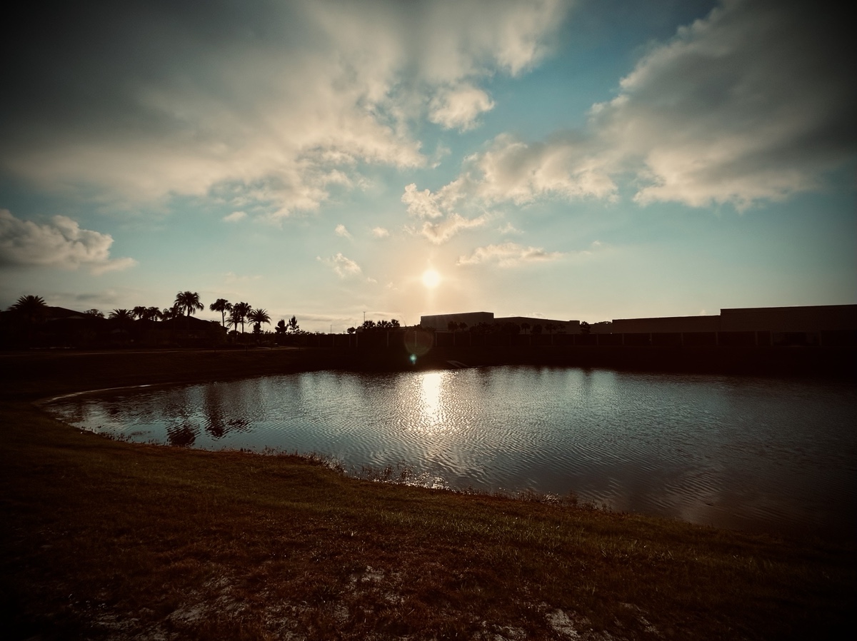 Sunrise over a building and pond