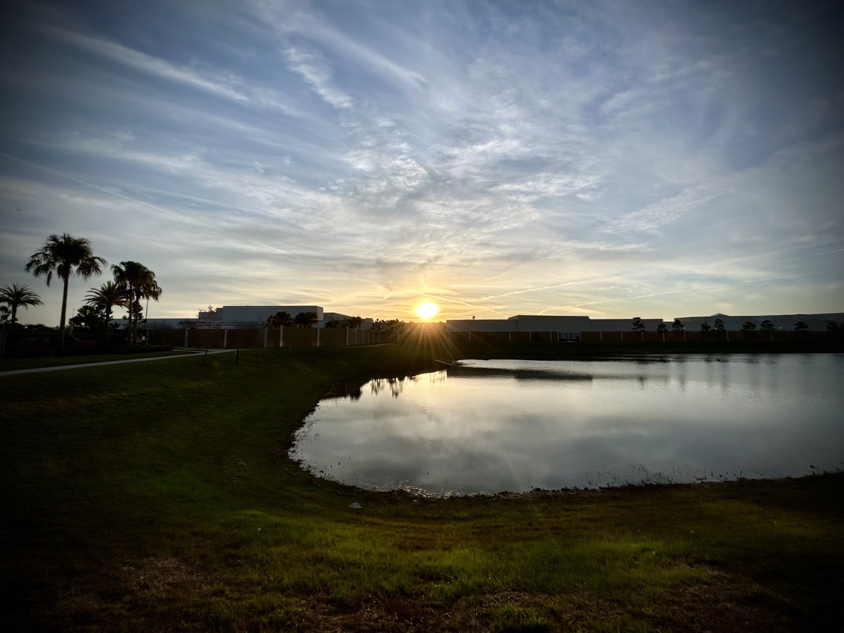 Sunrise over a building and pond