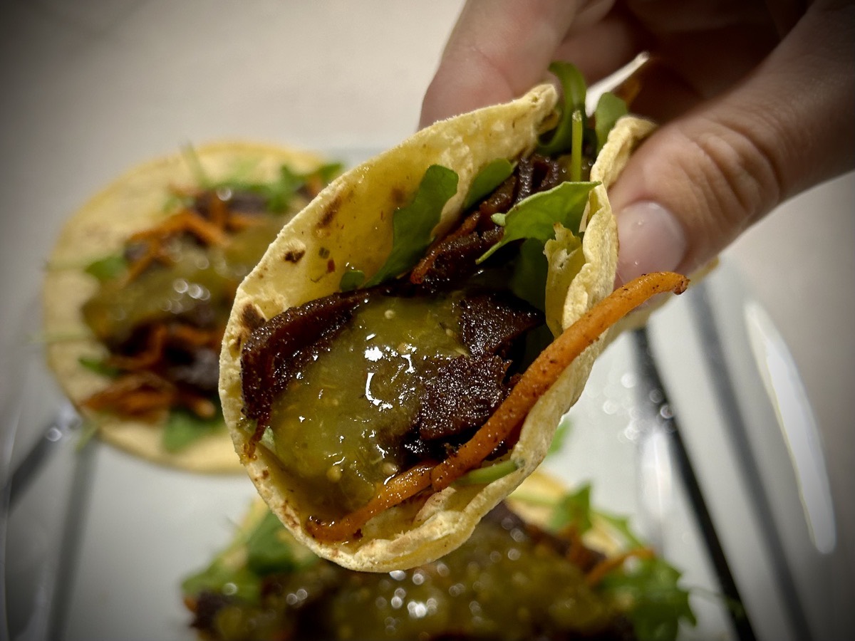 Close up of a plant-based "steak" taco in hand