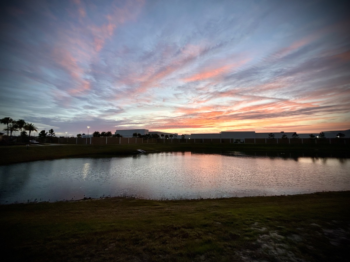 Dawn sky over a building and pond