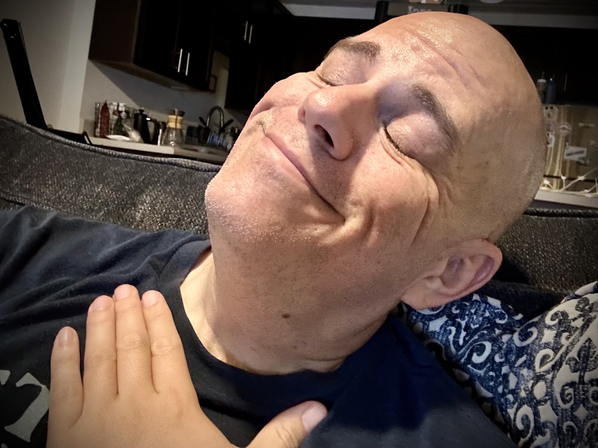 Selfie where I'm holding my chest, face poised upward with my eyes closed while smiling