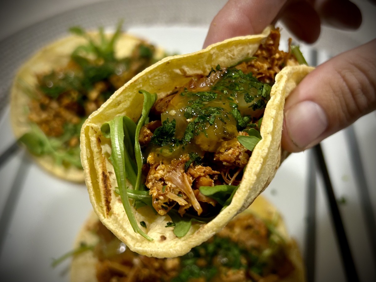 Close up of a jackfruit and tofu taco in hand