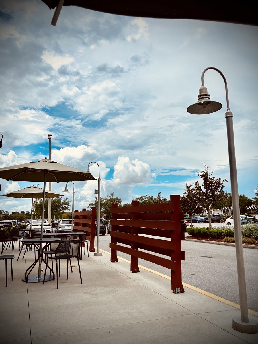 Cafe tables, parking lot, clouds in the sky